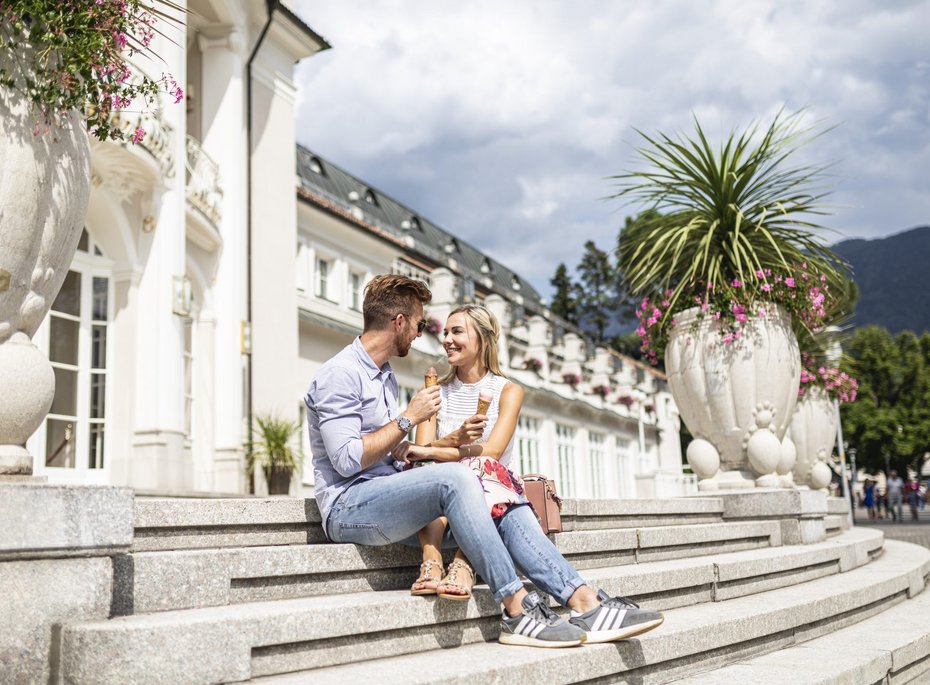 Ein Mann und eine Frau sitzen mit Eis auf einer Steintreppe.