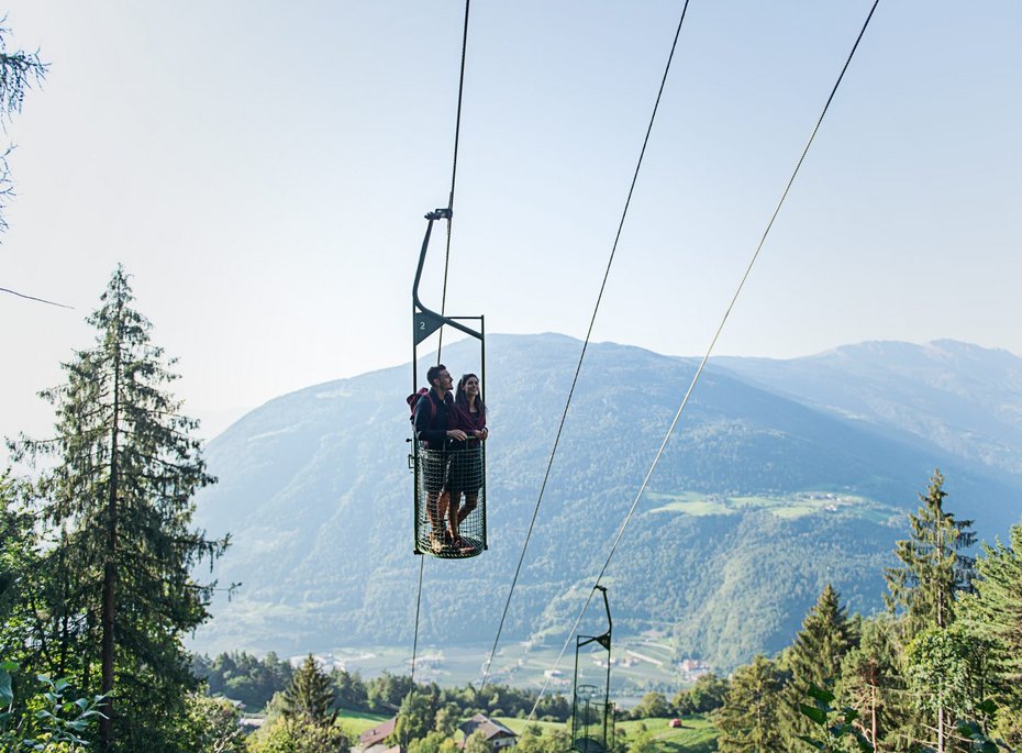 Ein Mann und eine Frau in einer zwei Personen Seilbahn.