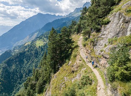 Personen auf einem schmalen Wanderweg.