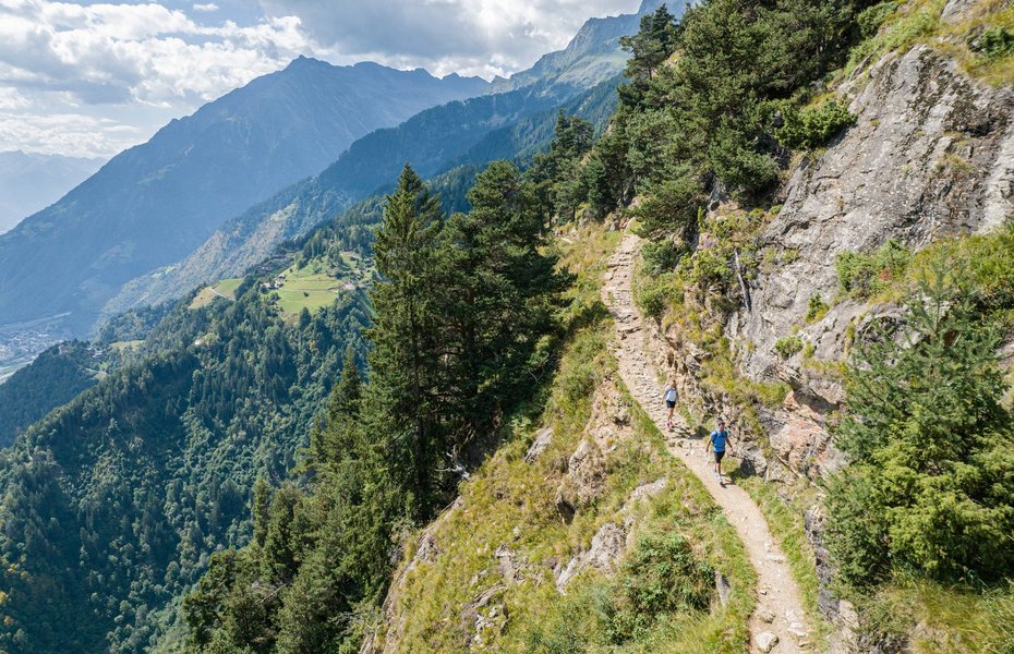 Personen auf einem schmalen Wanderweg.